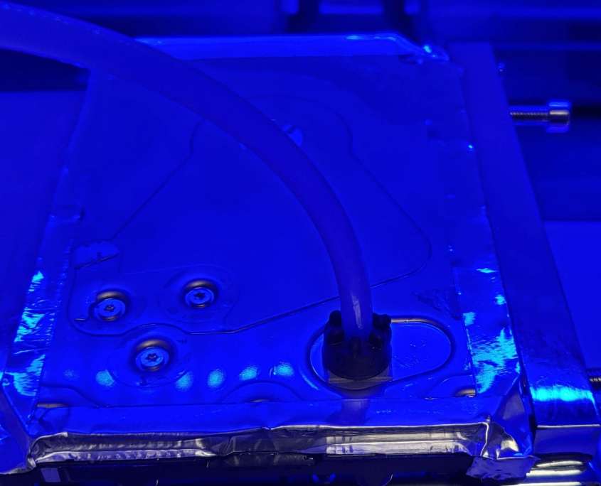 Helium being fed into a resealed hard drive enclosure through the release port during a refill